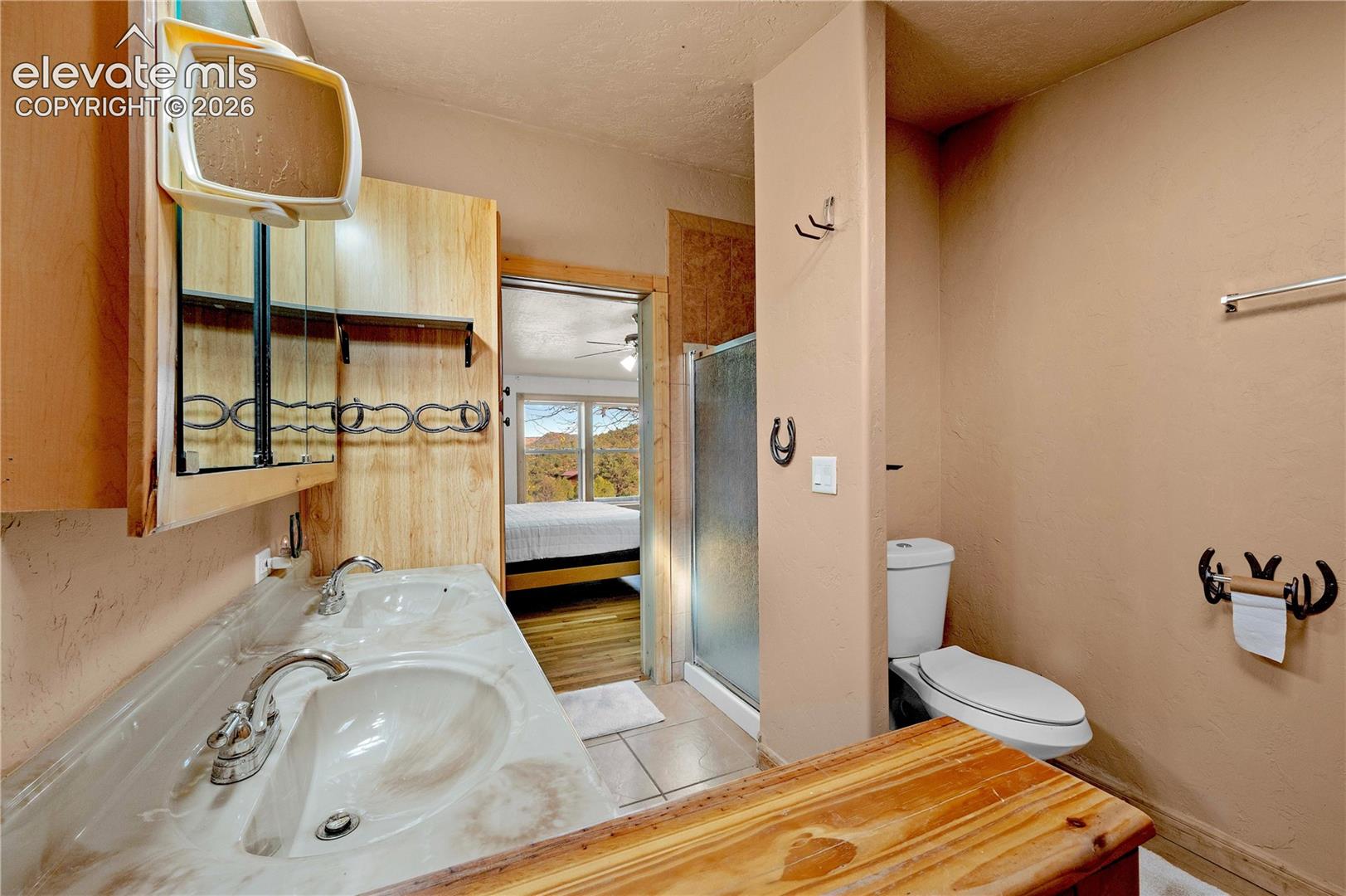 Bathroom with a textured ceiling, an enclosed shower, toilet, tile patterned floors, and vanity