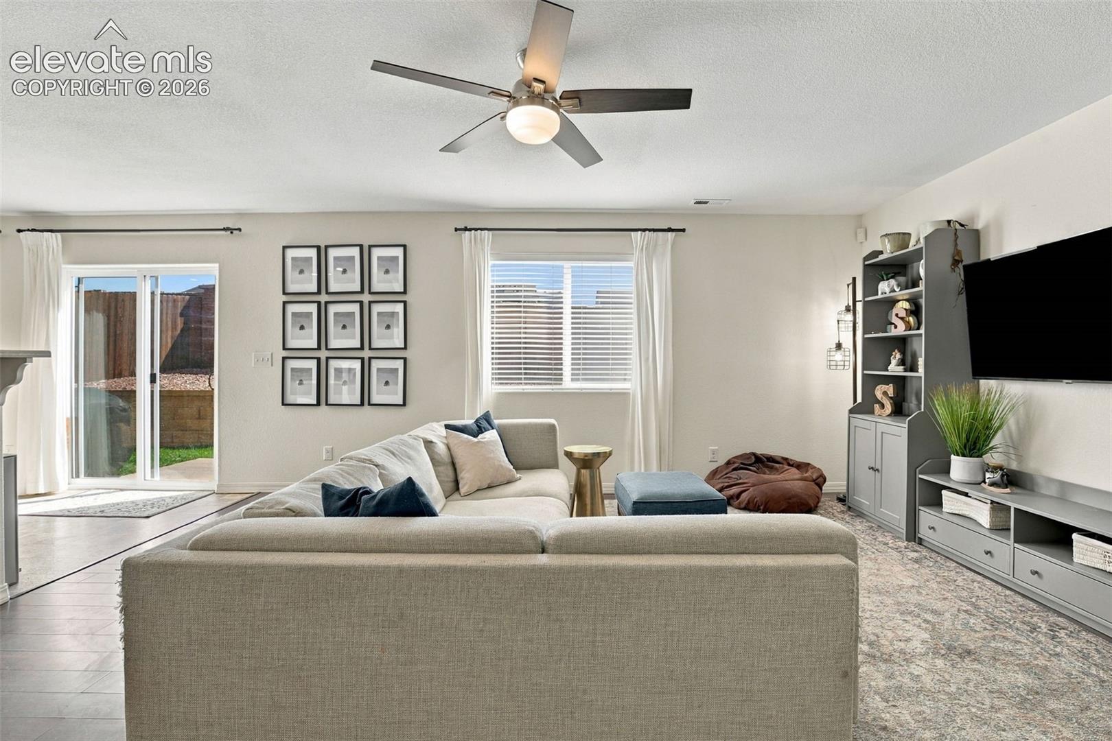 Recessed lighting, ceiling fan, wood-finish flooring, sliding glass door, and built-in shelving