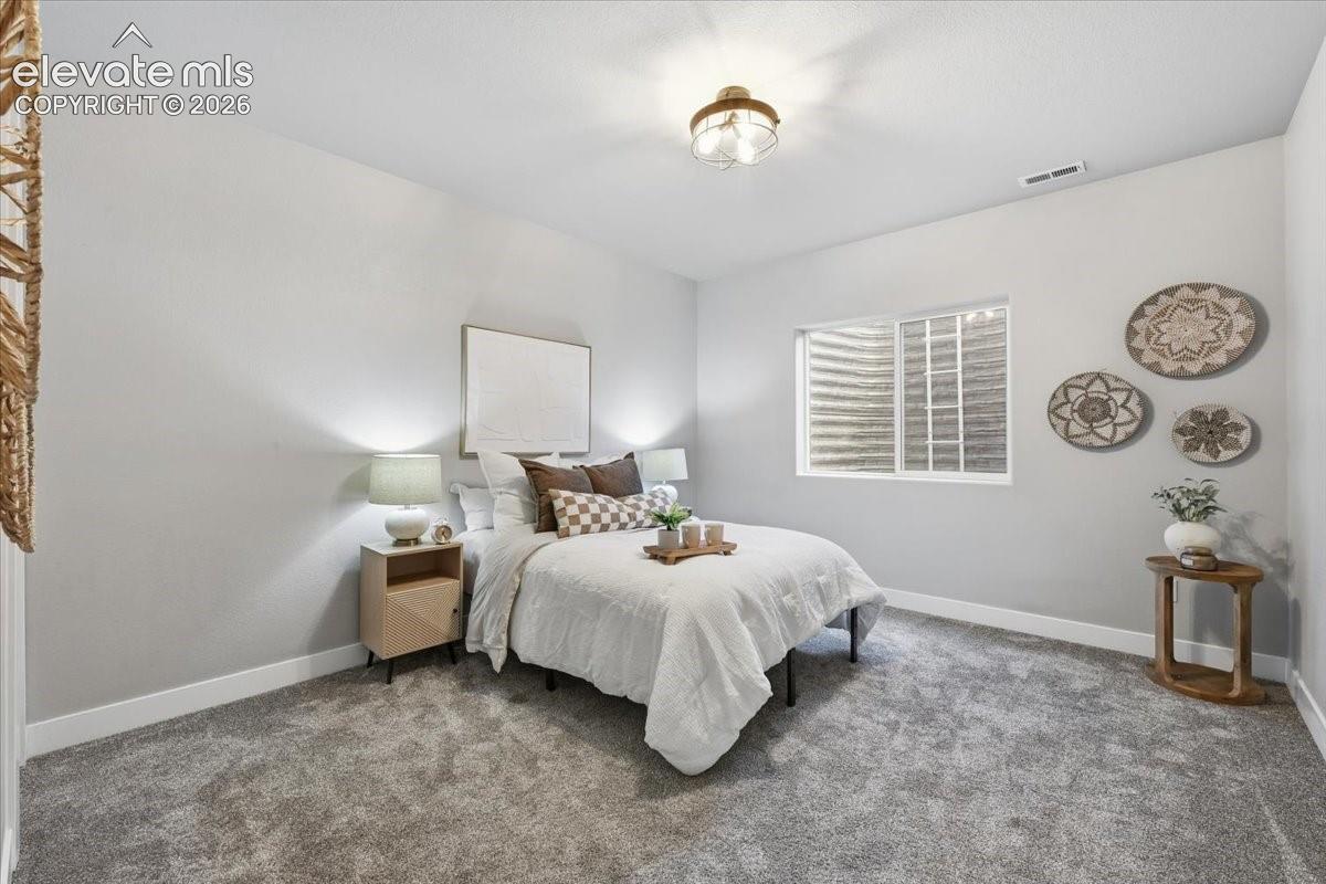 Light gray wall finishes, gray carpet flooring, egress window, and a flush-mount ceiling light fixture