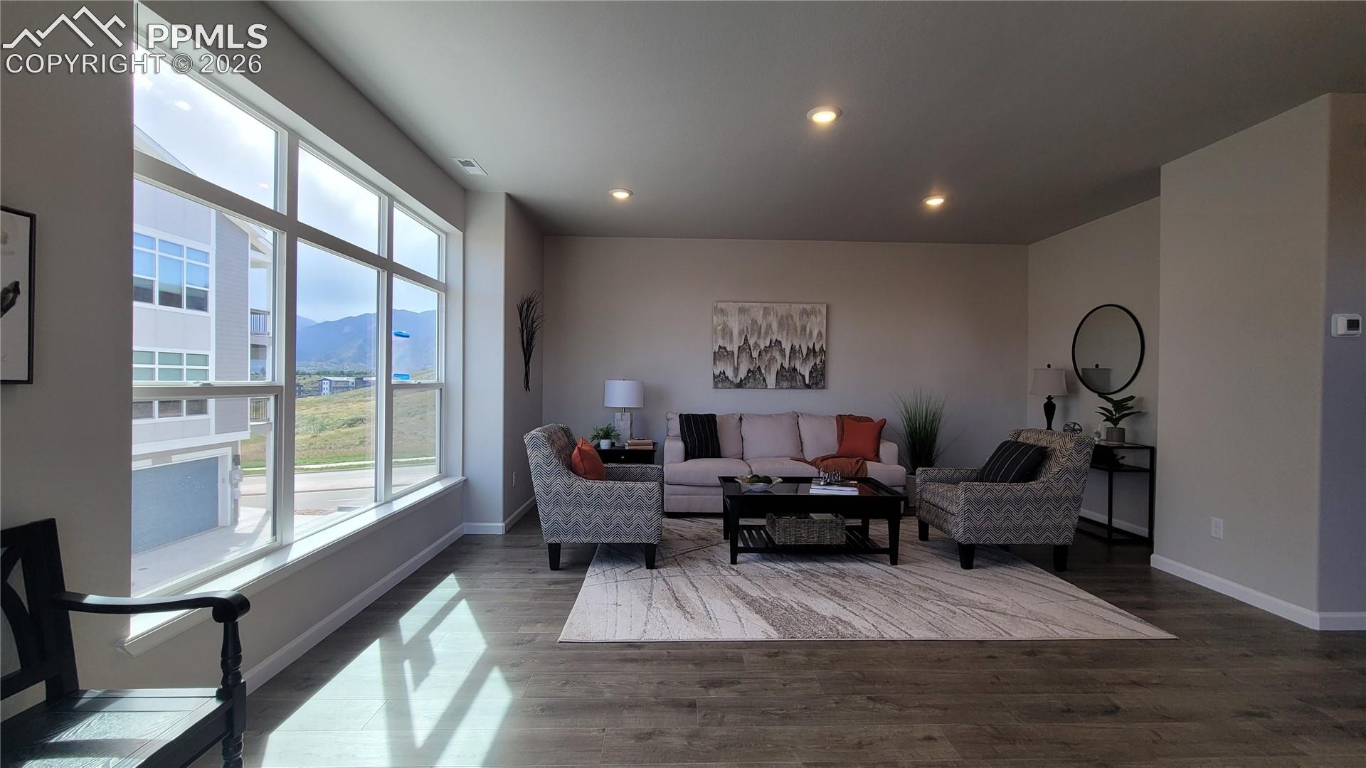 Living Room with LVP flooring, abundance of natural light, LED lighting, and walk out to private deck! 