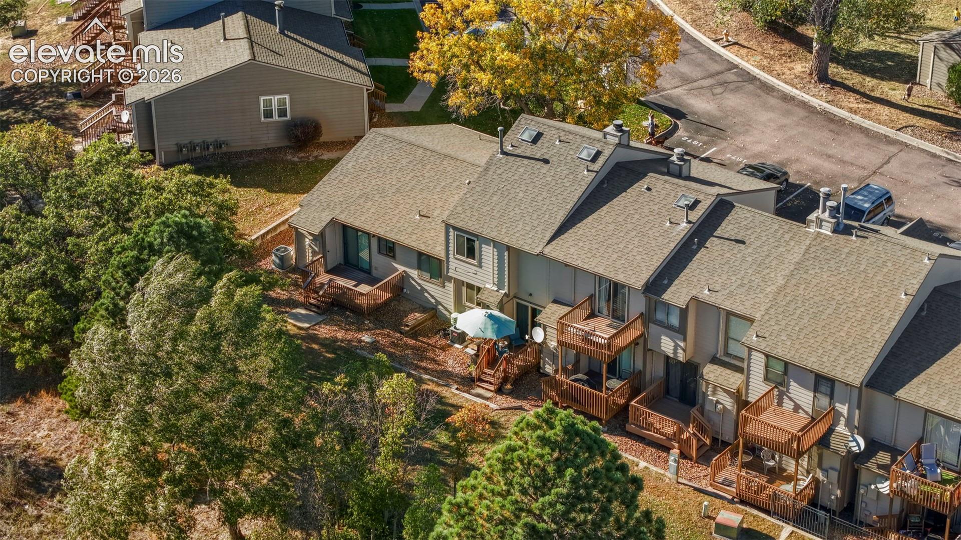 Multi-level residential complex featuring shingled roofing, stacked wooden balconies, skylights, and horizontal siding