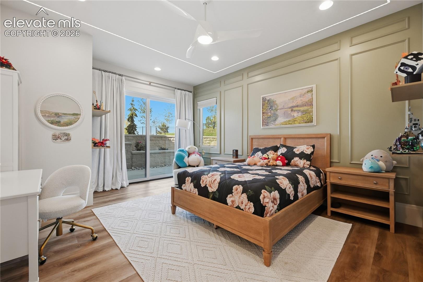 Bedroom featuring wall-applied decorative molding, wood-finish flooring, recessed lighting, ceiling fan, and sliding glass door