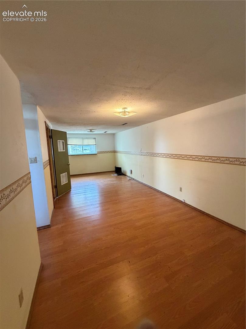 Wood-finish flooring, flush-mount ceiling light fixtures, and window with horizontal blinds