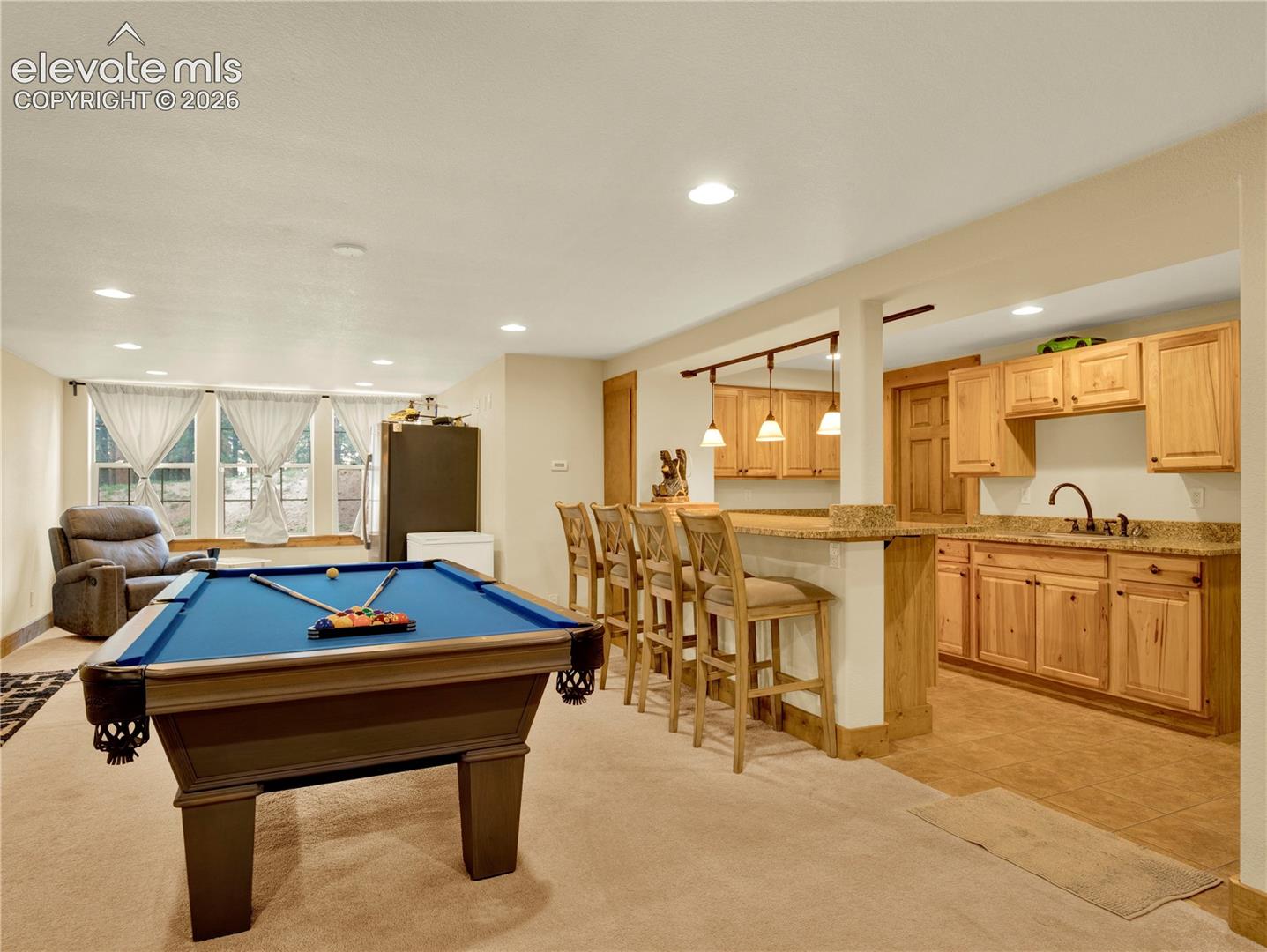 Lower level entertainment space with full wet bar and space for a pool table