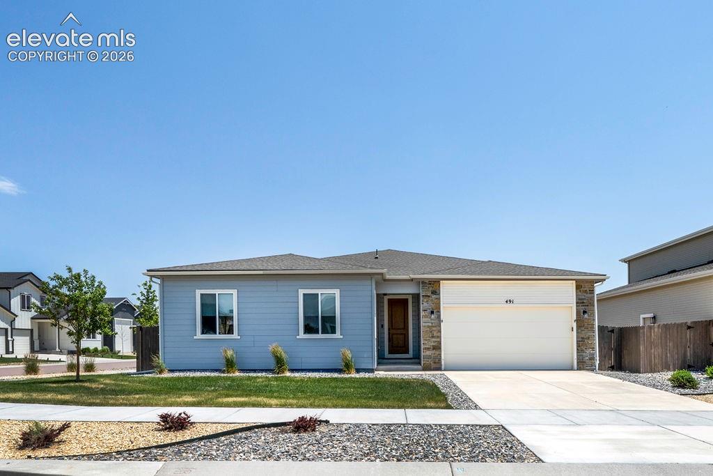 Ranch-style residence featuring light blue siding with white trim accents and a stone facade