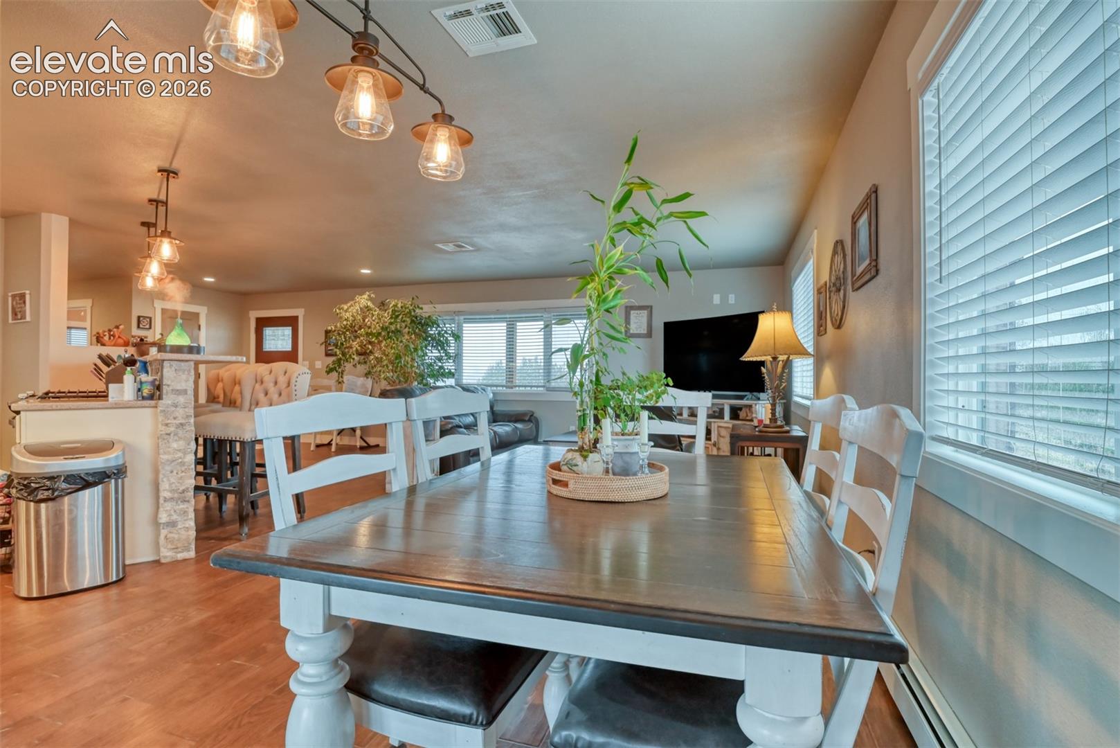 Dining area featuring wood finished floors and baseboard heating