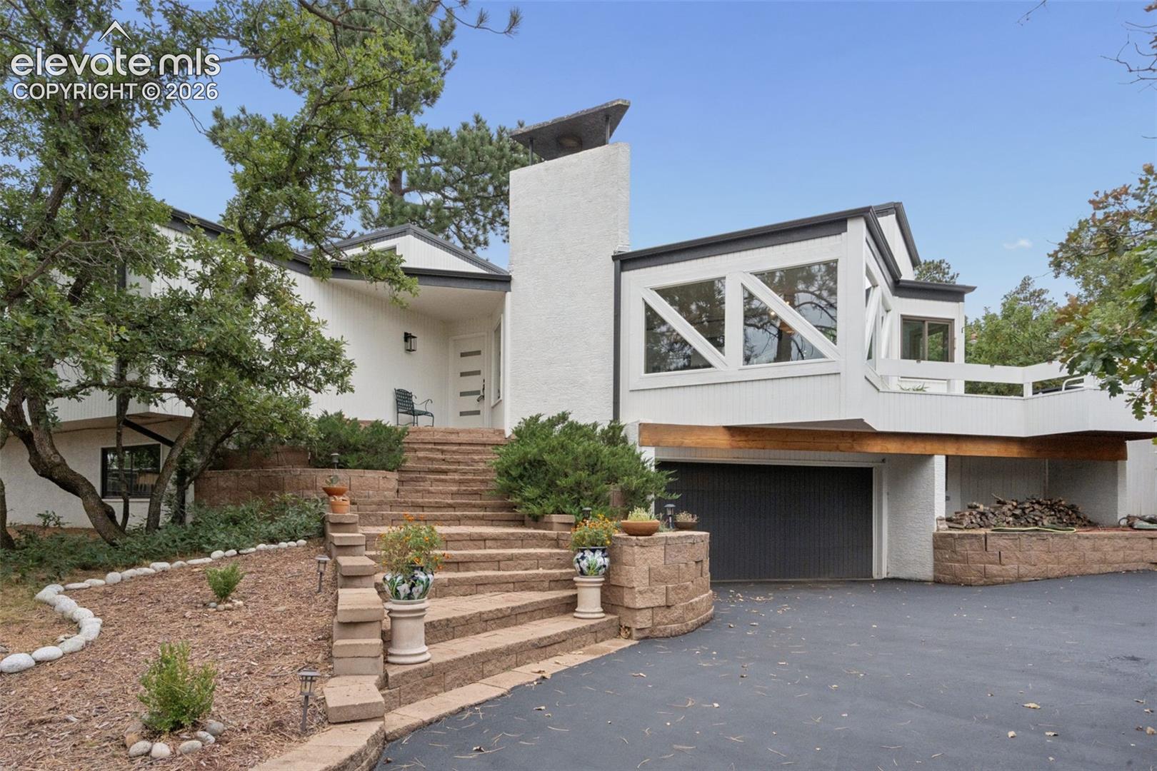 Stunning architectural showpiece located in the coveted Skyway neighborhood that demands your attention from the moment you turn into the driveway. The home's presence immediately signals that you will experience a luxurious and unique residence unlike any other. When you open the front door you are greeted by an open, bright layout that flows seamlessly from one space to the next, offering all the modern amenities expected in a remodeled, move-in-ready home. The main level family room is a show stopper with its stunning windows and one of a kind wood burning fireplace. A few steps up reveals a fully updated kitchen featuring stainless steel appliances, quartz countertops, a custom backsplash with floating shelves, and a large pantry to top it off! When it is time to retreat for the night the primary suite offers the amenities you would expect from a 5 star resort. From the oversized bedroom that walks out to its own private backyard deck, to the incredible 5 piece bathroom complete with a walk-in shower, freestanding tub, floating vanities, touch-activated faucets, and a large skylight bringing the outdoors inside! The basement continues with additional space ready for entertaining. The large family room is highlighted by a sunken sitting area around a brick wood burning fireplace, situated next to a wet bar complete with a mini-fridge for your favorite beverages. Two additional bedrooms and another full bathroom complete the space making it functional for any owner to use and enjoy. The oversized 2 car garage has ample space for workbenches, lawnmowers, and tools. Outside the backyard is a private oasis surrounded by scrub oak and pine trees, making you feel miles from the city limits. To top it all off, you are minutes from Bear Creek Park, with easy access to downtown Colorado Springs and Old Colorado City, as well as coveted and sought-after District 12 schools. This is a unique and one-of-a-kind opportunity!