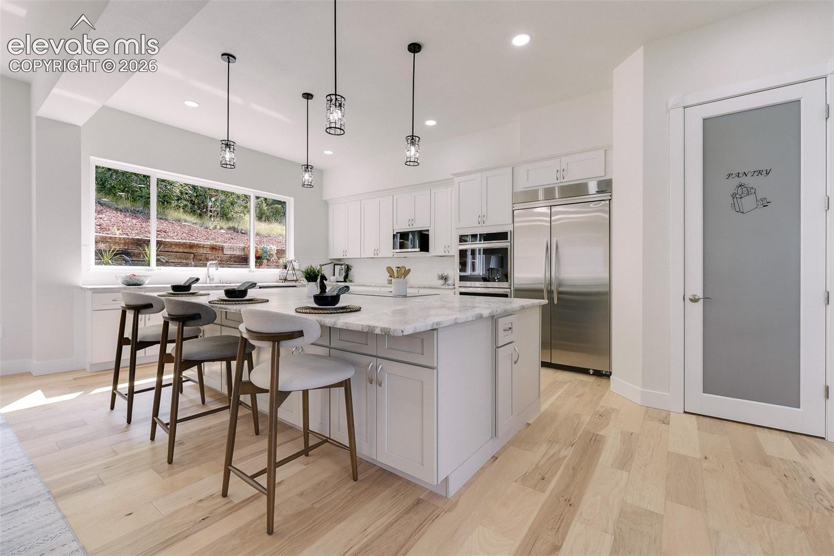  The gourmet kitchen, features natural wood cabinetry, stone countertops, an oversized island, dual dishwashers, 2 ovens, a downdraft range, wine cooler, & premium appliances designed for effortless entertaining.