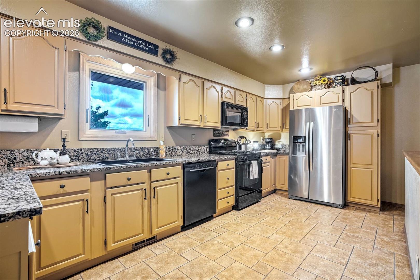 A chef's delight- ample cabinetry, pullout to right of frig for food/spice storage, gas range/oven, granite counters, overhead lighting, window to east-meadow views