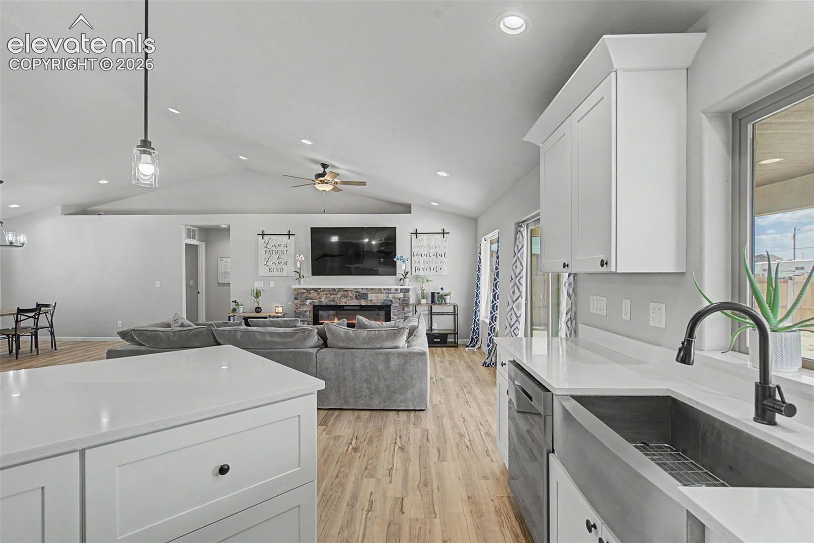Kitchen island with white shaker cabinetry and a solid surface countertop