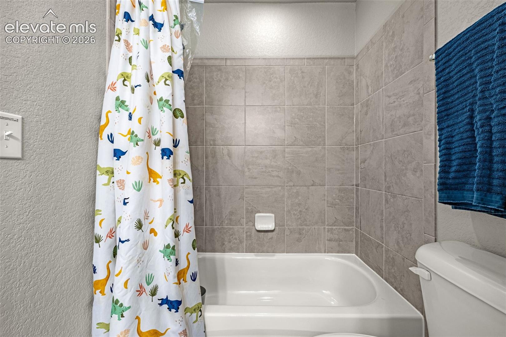 Bathtub with light gray tile surround
