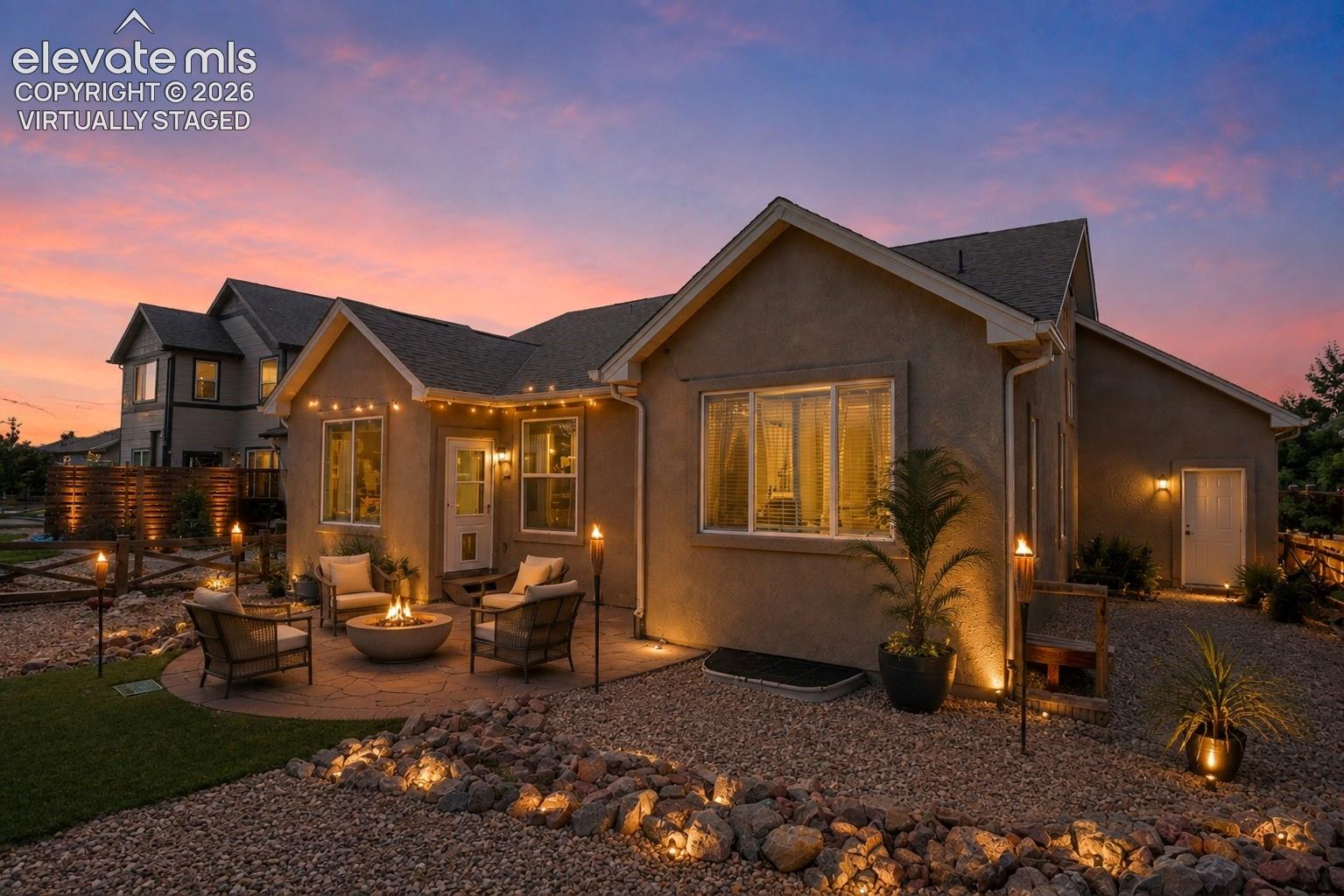 Virtually Staged - Stucco exterior with a paver patio, a built-in fire pit, and landscape lighting