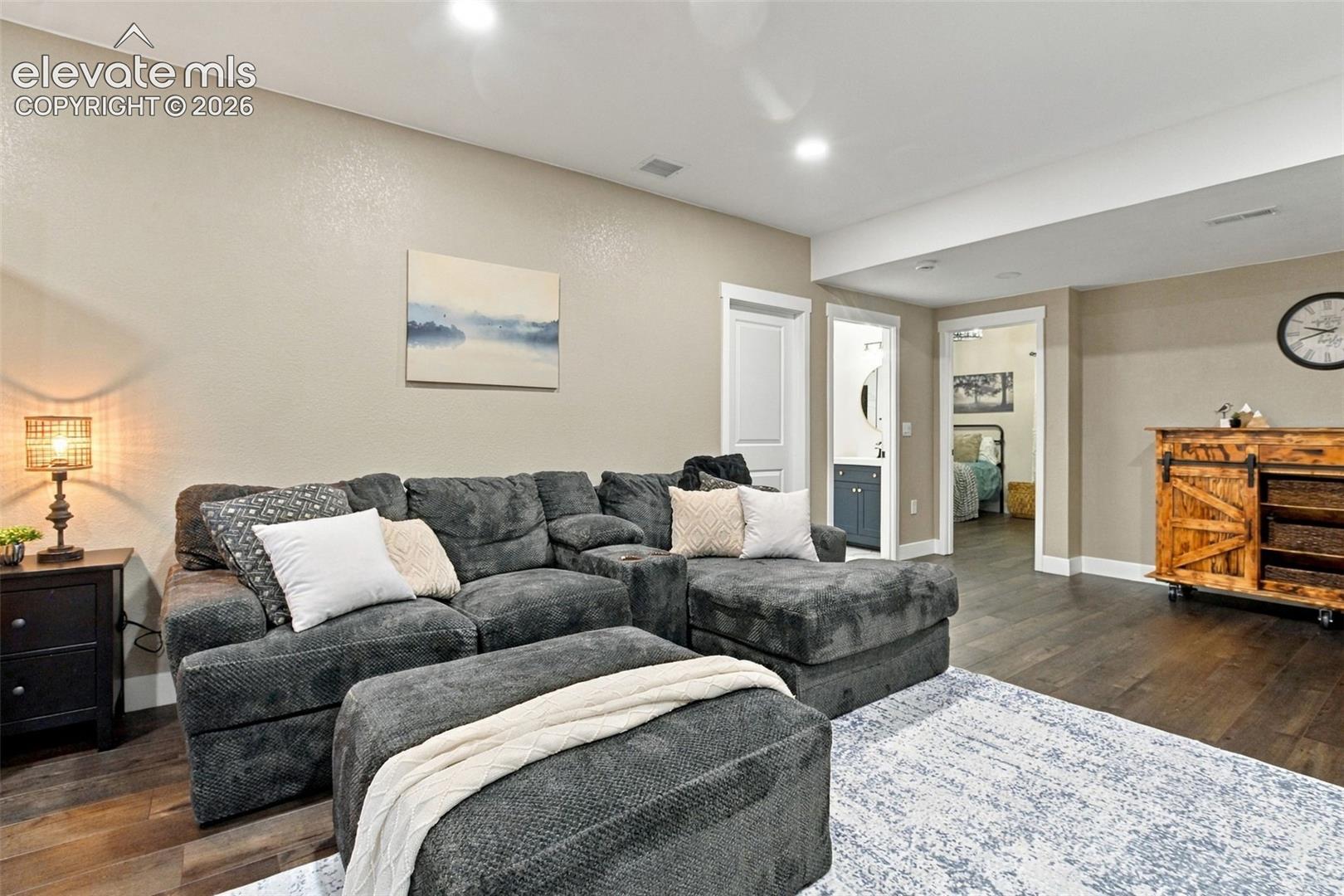 Neutral-toned walls, recessed lighting, and dark wood-finish flooring