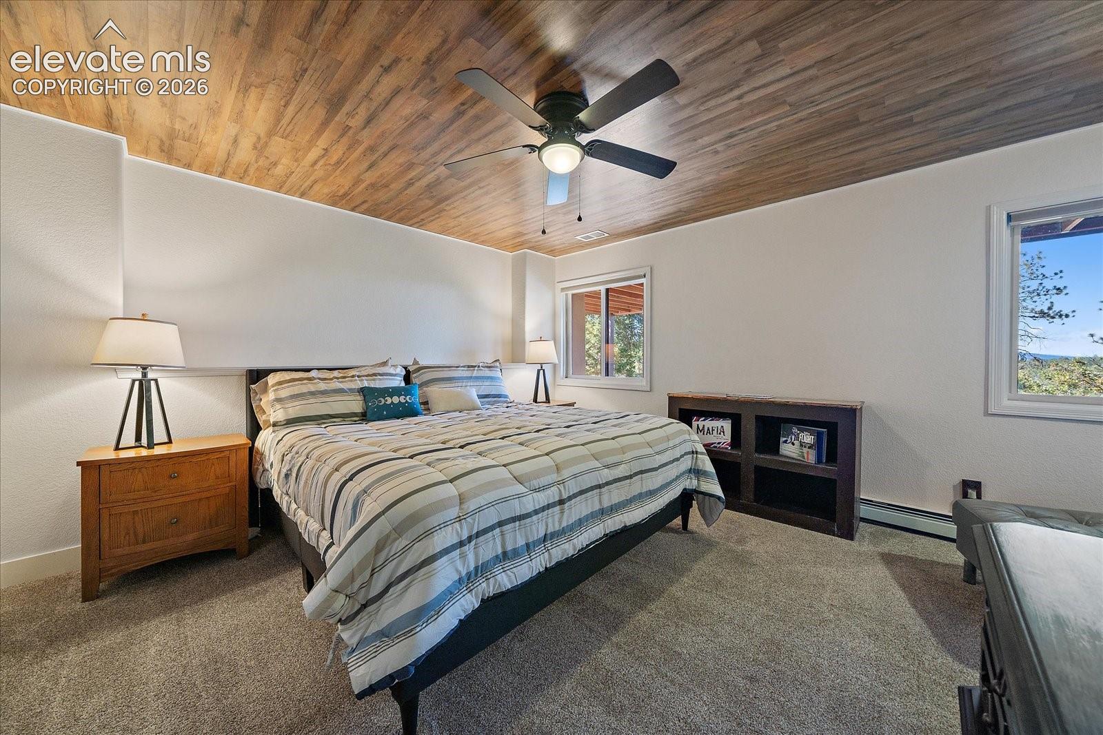 Vaulted wood-finish ceiling, central ceiling fan, neutral wall finishes, and built-in low-profile cabinetry