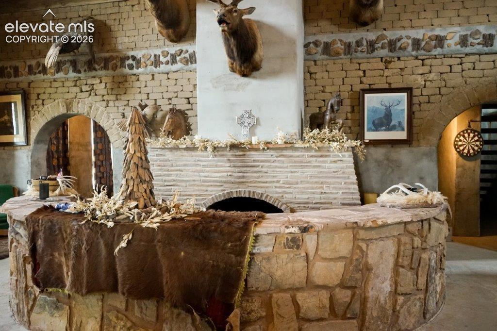 Living Room/Great Room with adobe brink wall, brick fireplace with sunken stone sitting area