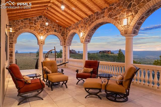 Covered deck with stone arches, tongue-and-groove ceiling, and unobstructed Front Range views.