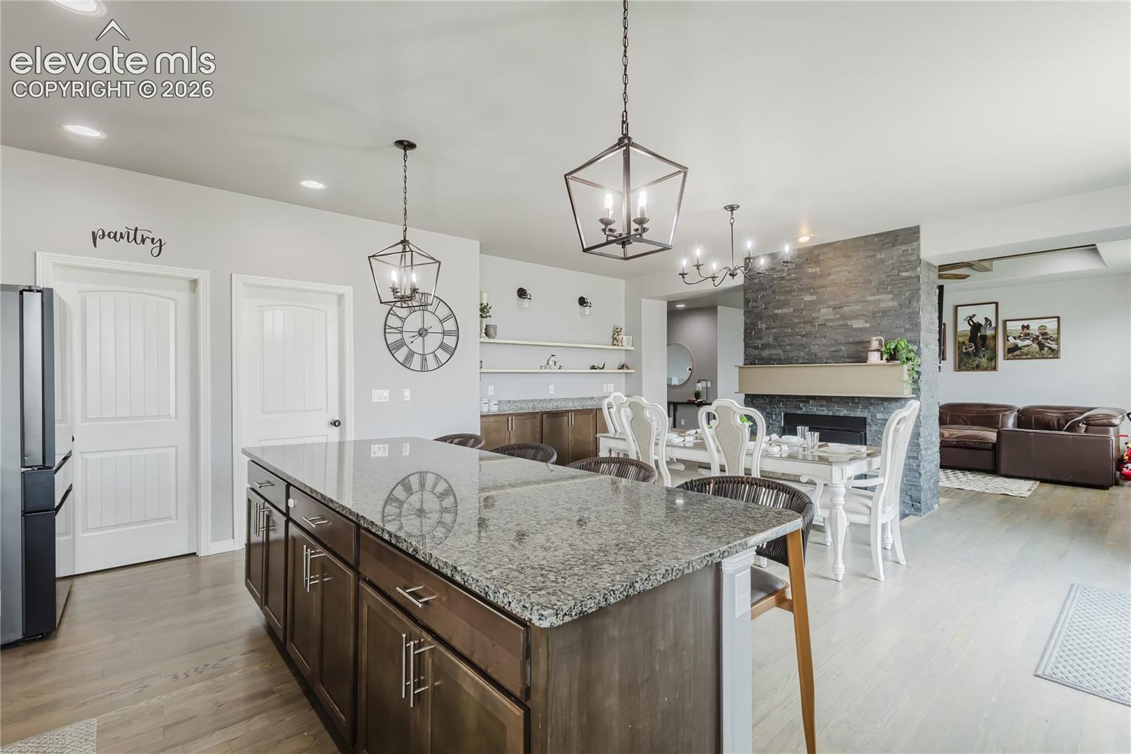 Kitchen island with granite countertop and dark wood cabinetry