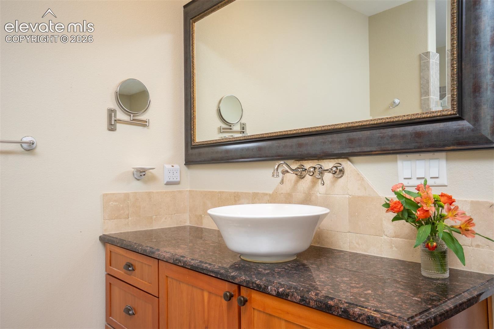 Notice the beautiful granite, table top sink, and framed mirrors