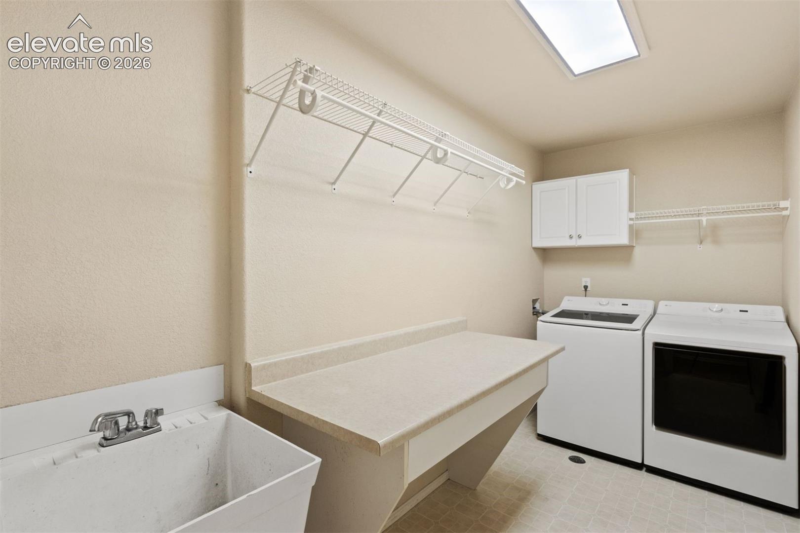 Main level laundry room with storage and sink