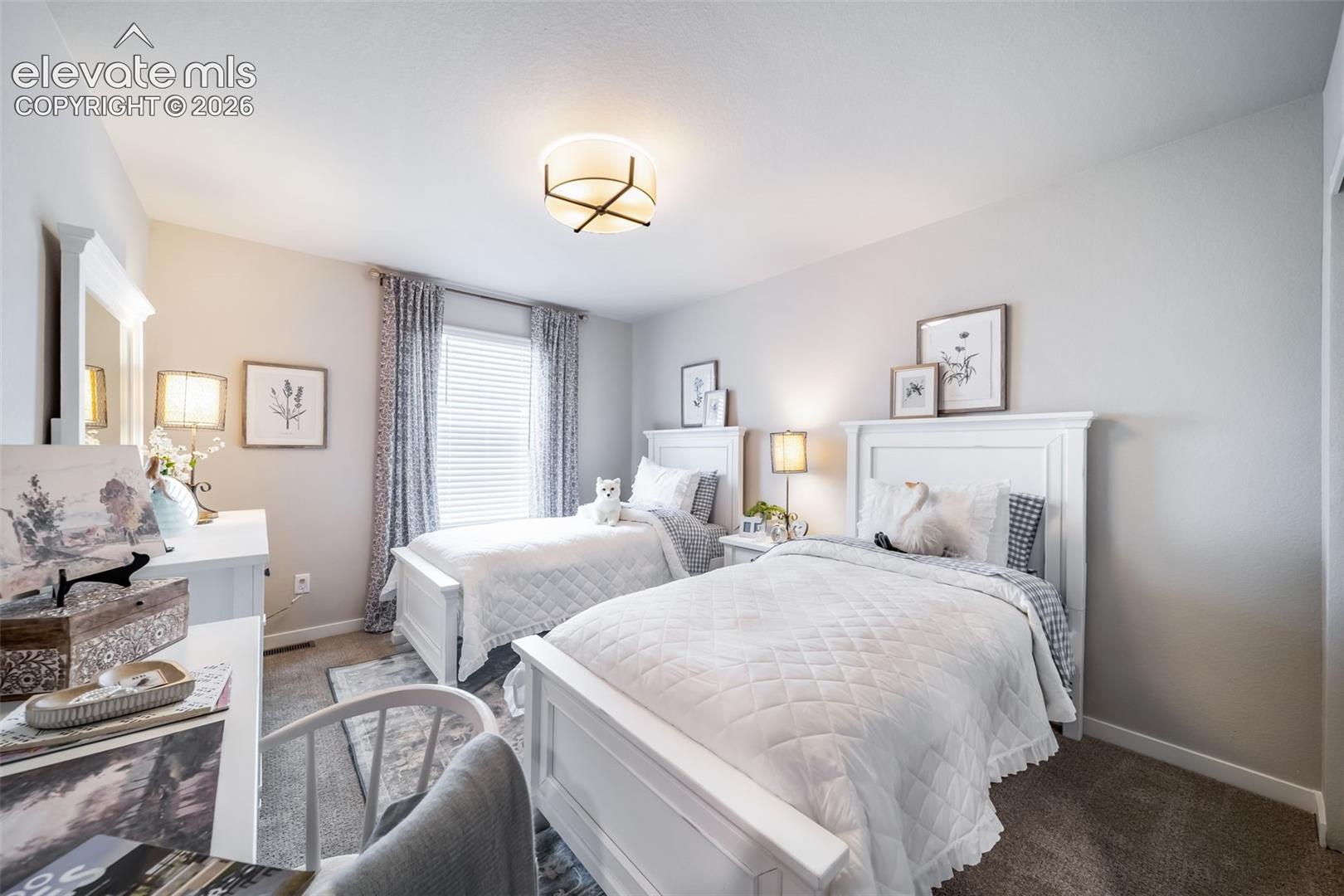 Carpeted bedroom with neutral wall tones and a ceiling-mounted light fixture
*Photos of a model home*