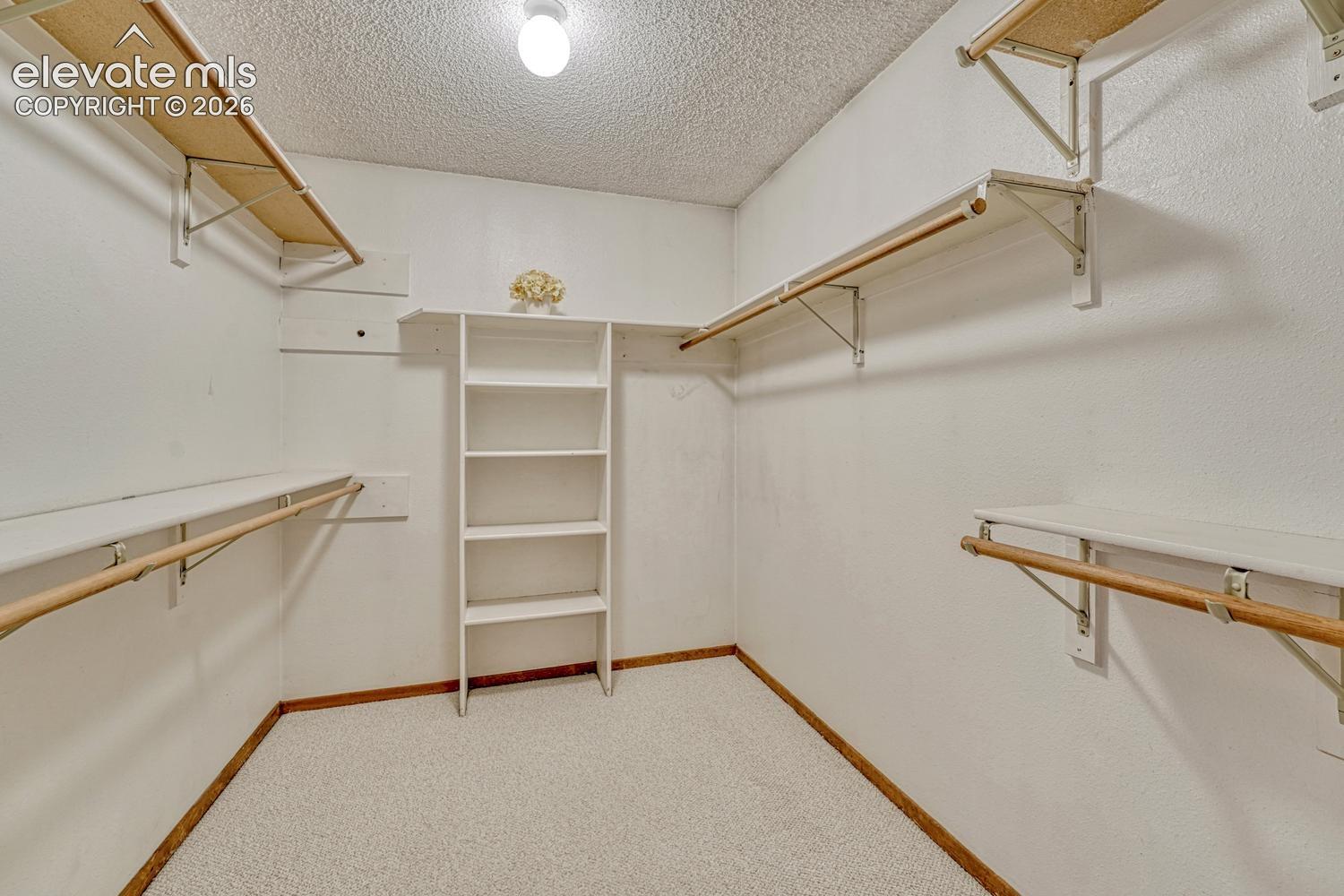 Walk in closet with organizer and built in shelves in the primary bedroom.