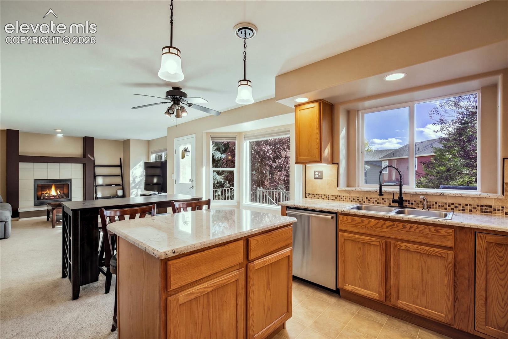 Pendant lighting highlights the breakfast bar, providing convenient seating for casual meals or conversation while preparing dinner.