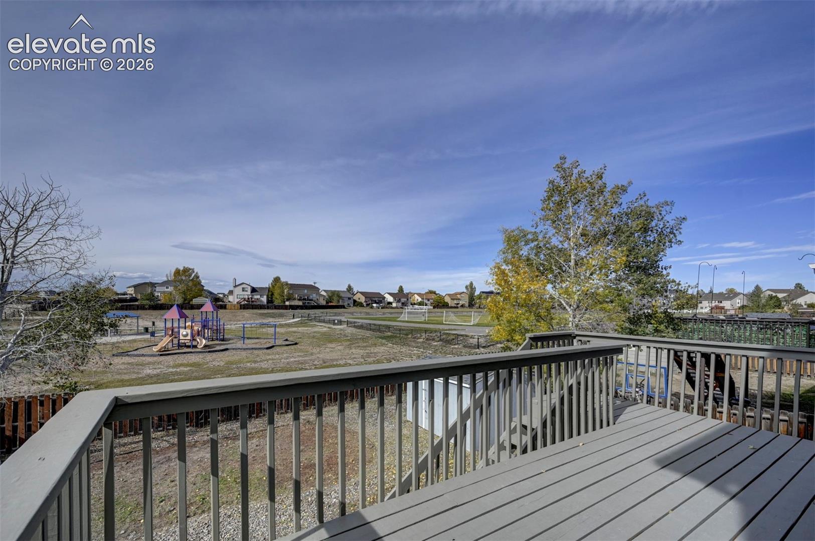 Elevated composite deck featuring painted wooden railing and stairs