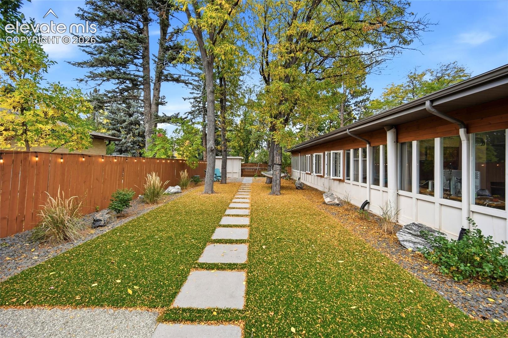 The side yard features a patio seating area and the perfect spot for a hammock. 