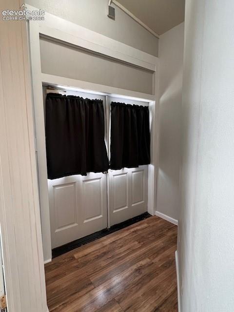 Double-entry doors featuring a white paneled finish, topped by a built-in transom window with a white frame, complemented by wood-finish flooring