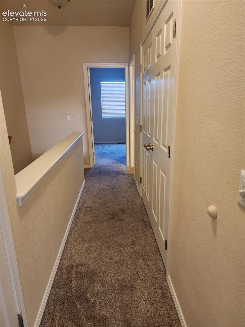 Upper level Carpeted hallway with a neutral color palette
