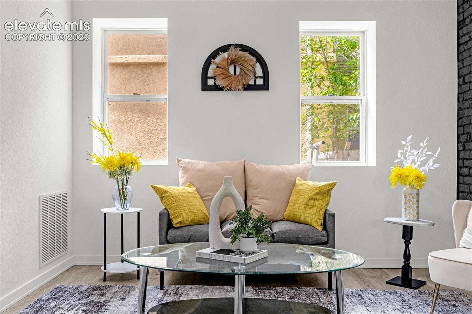 Bright living area featuring wood-finish flooring and white walls