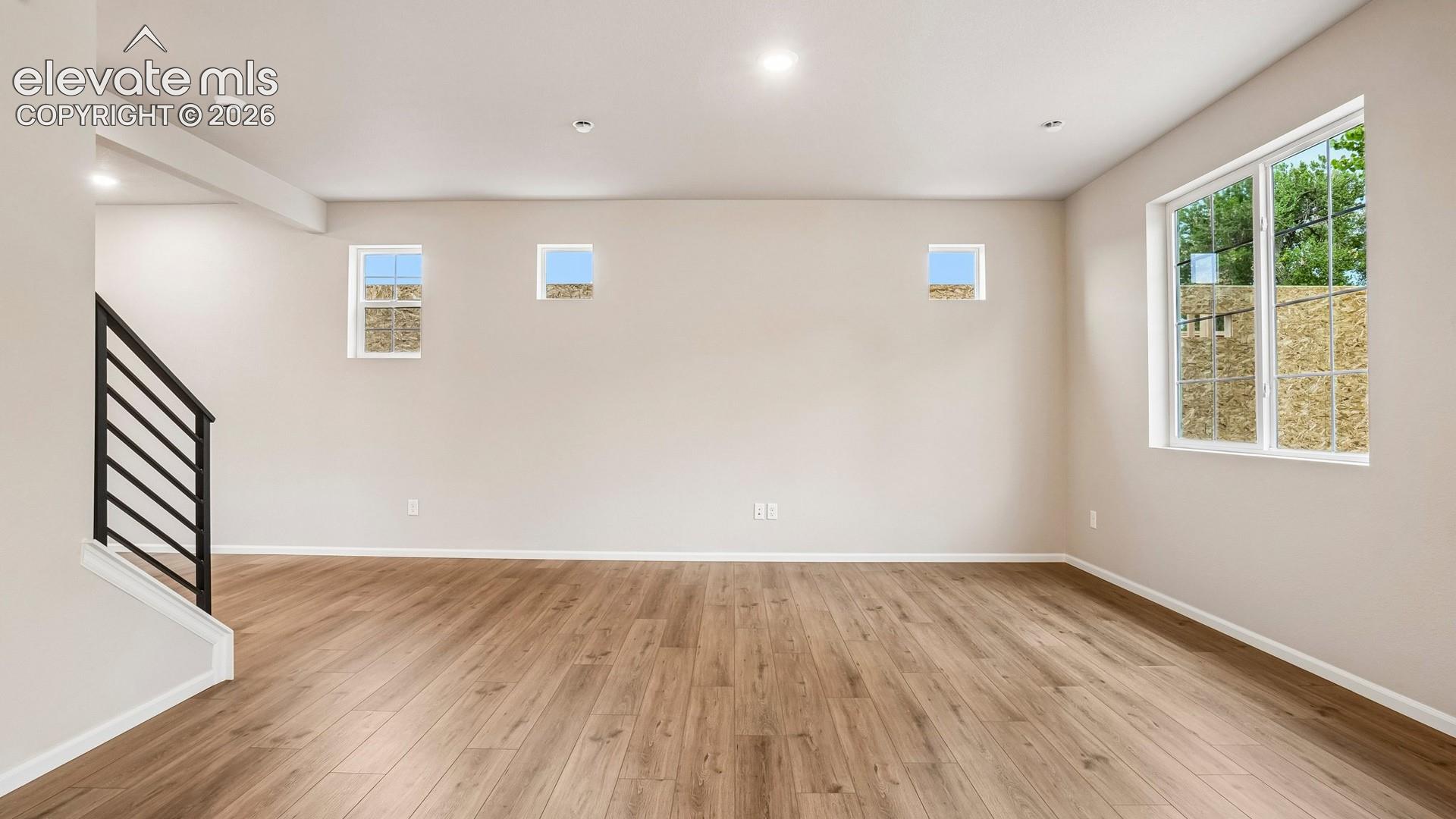 Spacious interior featuring wood-finish flooring, recessed lighting, and multiple windows
*photos of a model home*