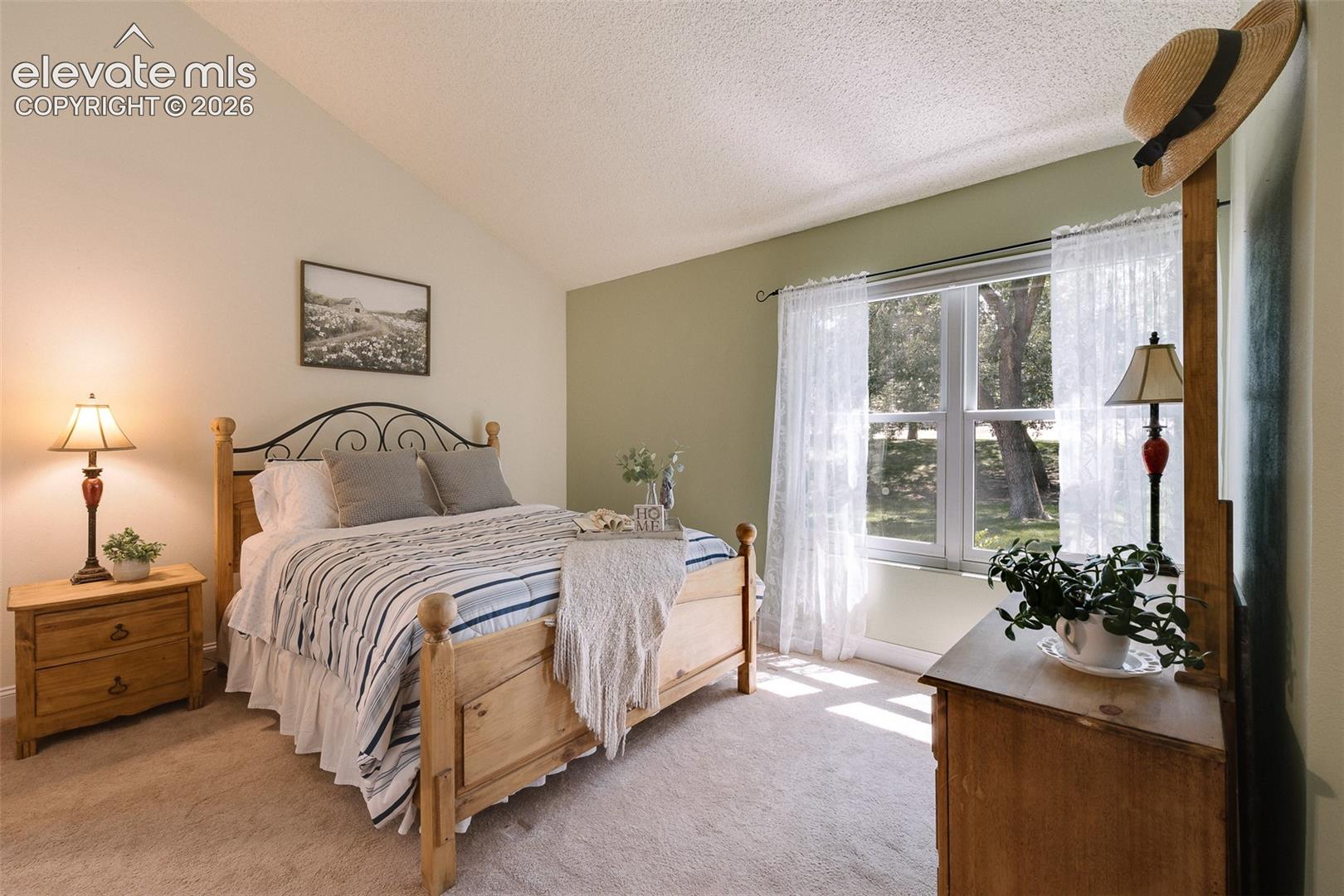 The main-level primary suite features double doors, a walk-in closet and private access to a beautifully appointed full bathroom with vanity, mirror, and tiled tub/shower.