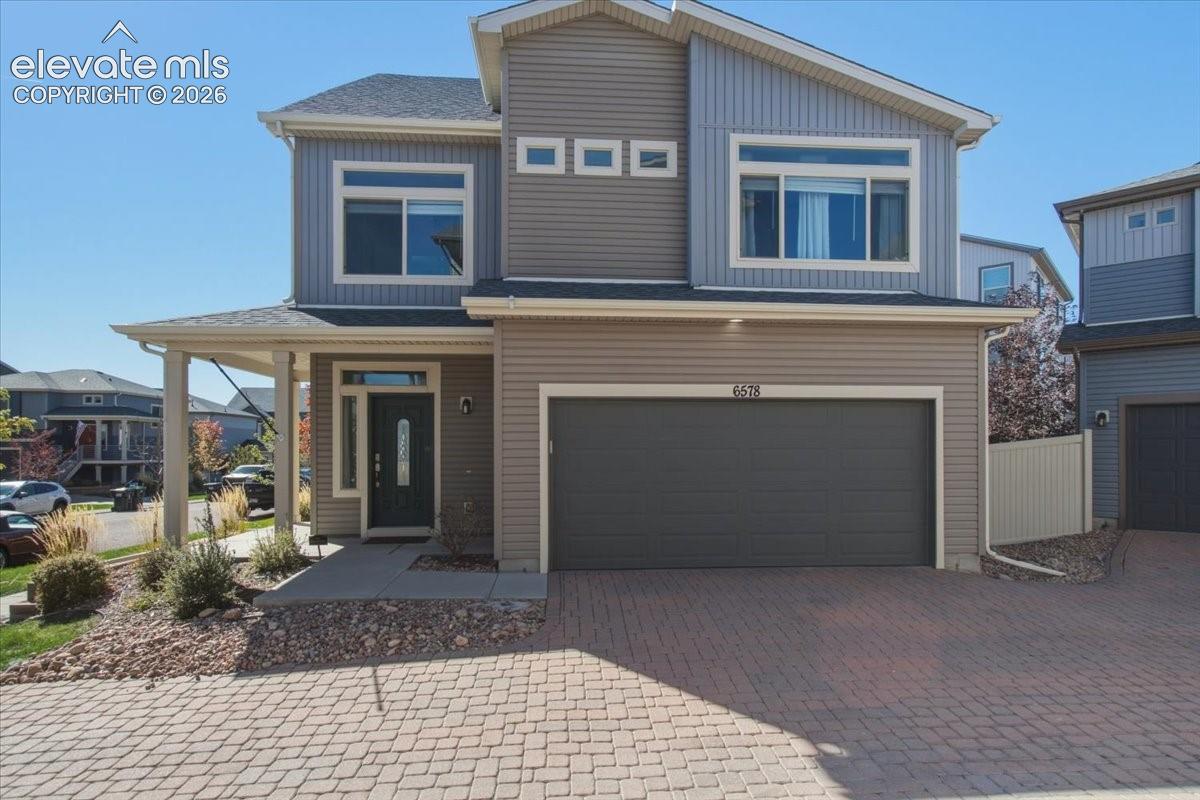 Multi-story exterior with mixed siding, covered entry, and an integrated garage
