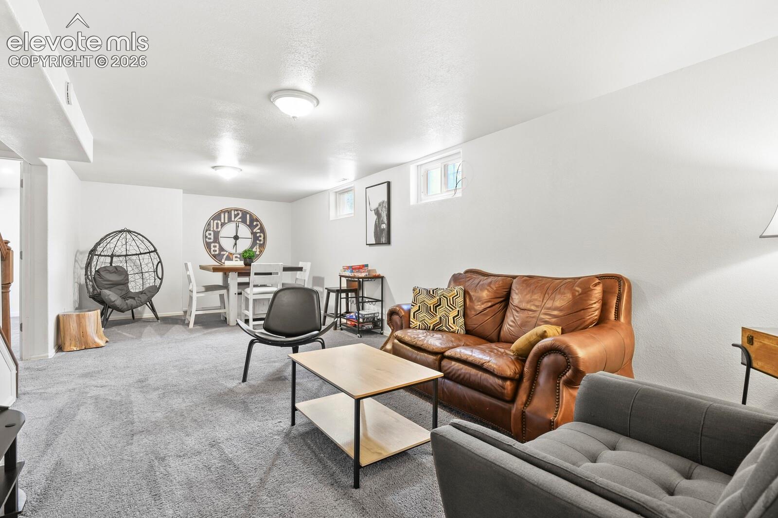 Living room area from far corner looking at TV area and dining/card/game table area on far end.