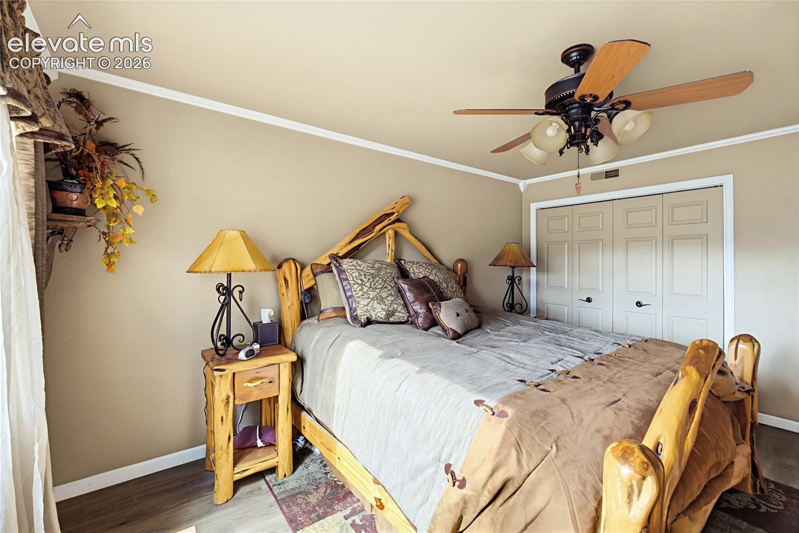 Wood-finish flooring, ceiling fan with integrated lighting, and dual-panel closet doors