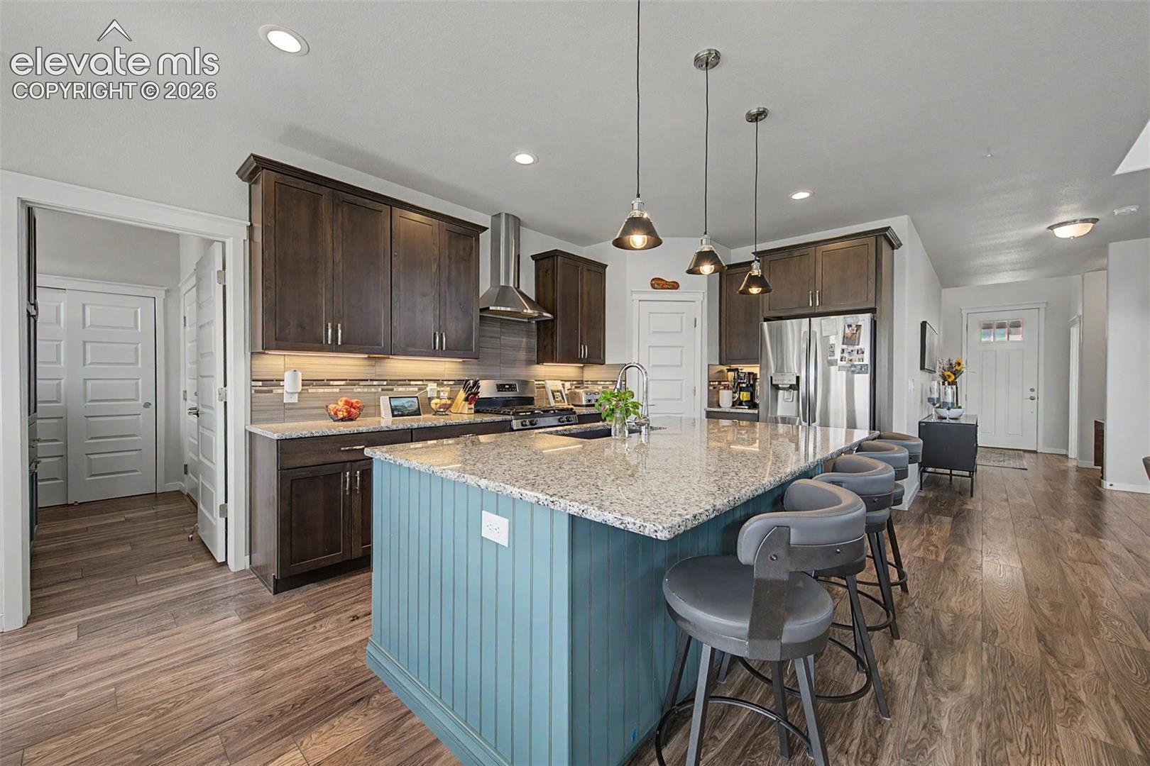 The inviting kitchen boasts a custom tile backsplash and informal seating at the island. Adjacent to the kitchen is an amazing mud room with a custom storage unit.  