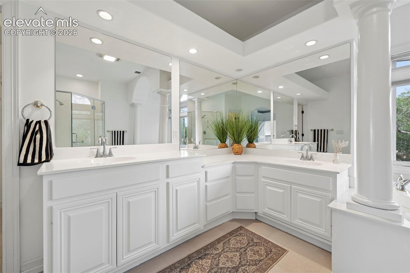 Expansive vanity area featuring dual integrated sinks with chrome faucets