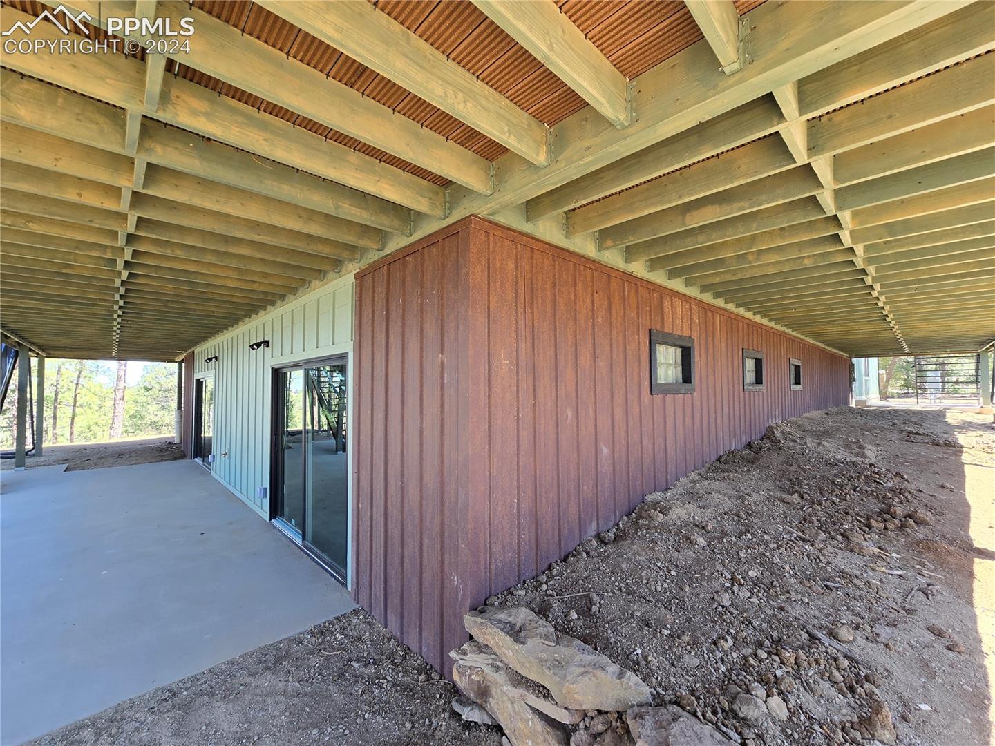View of lower level patiowith rusted steel siding over ICF foundation. 