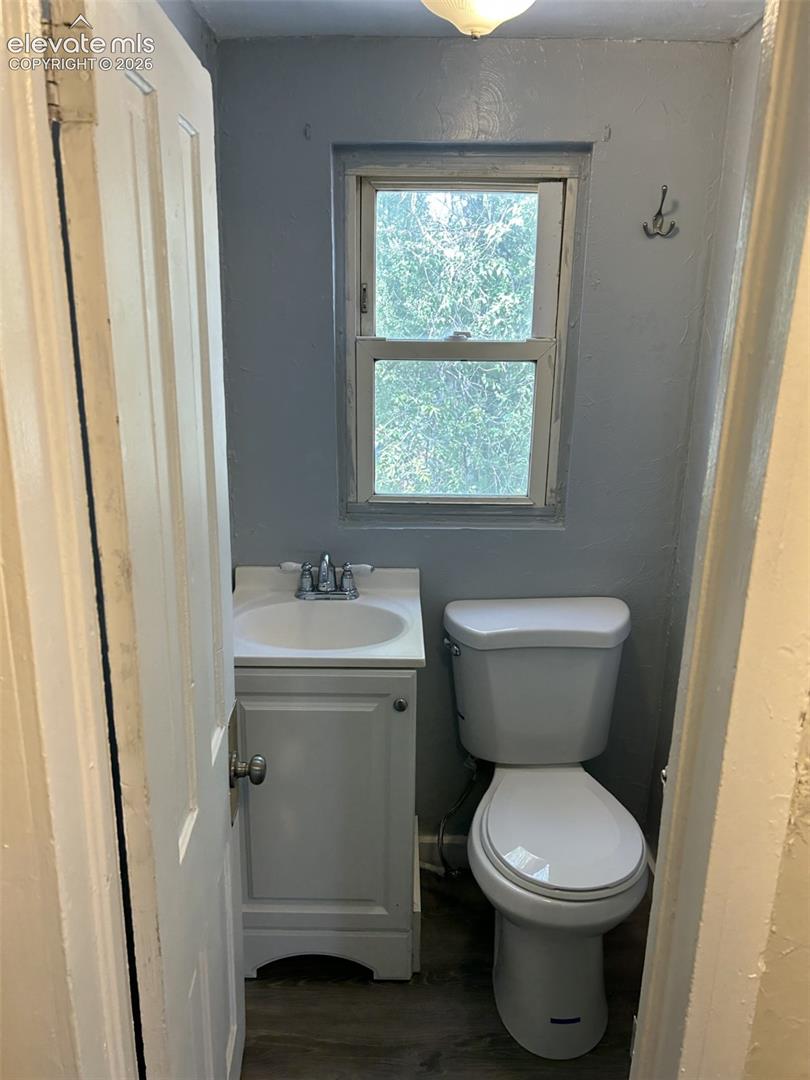 White vanity with integrated sink, chrome faucet, and white toilet