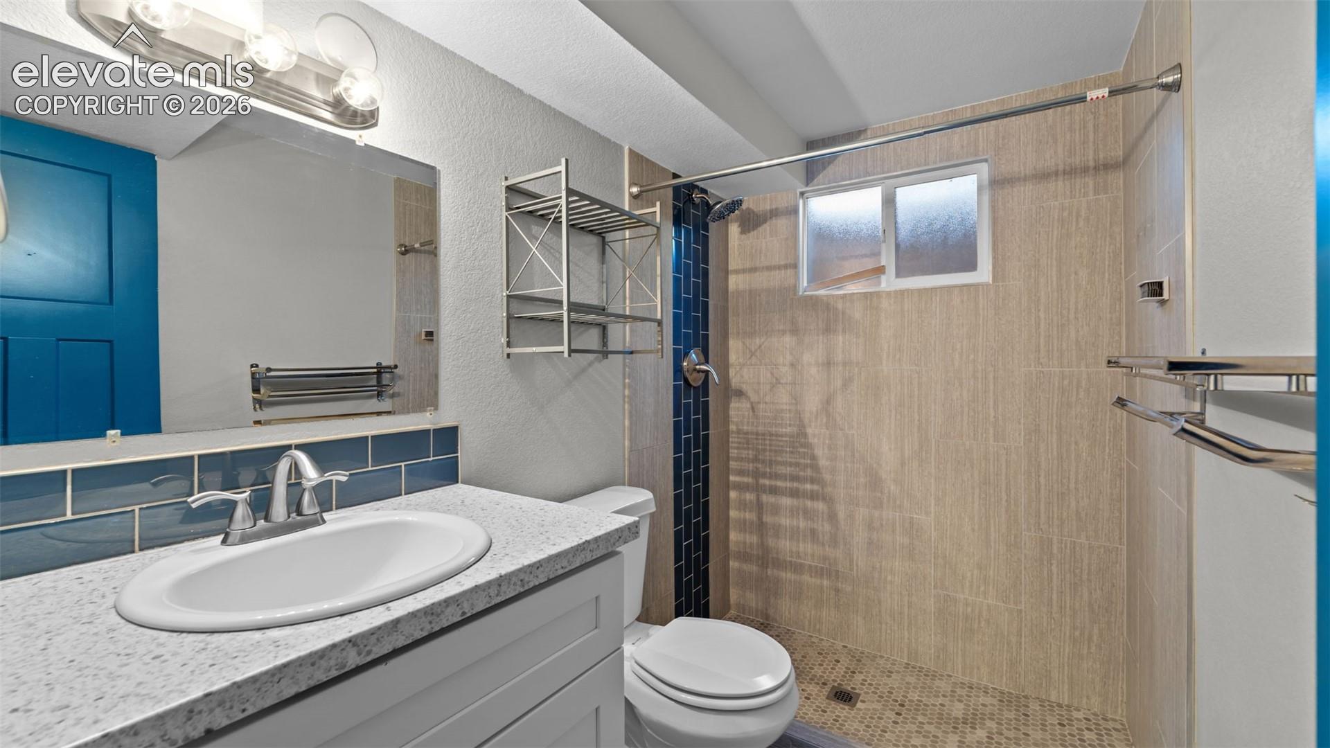 Vanity with an oval undermount sink, a wide-set faucet, and a speckled countertop
