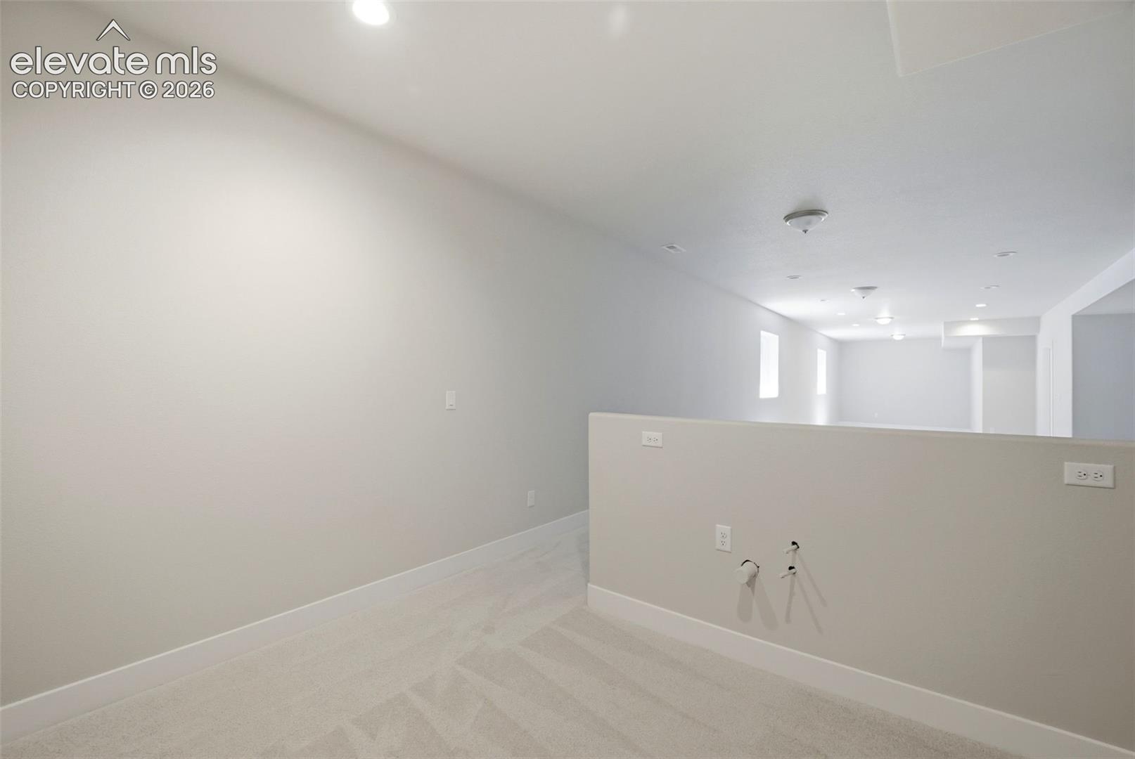 Open-concept interior featuring neutral-toned carpeting, recessed ceiling lighting, and crisp white wall finishes