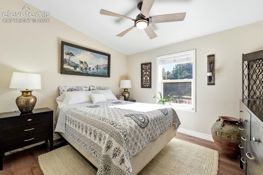 Wood-finish flooring, ceiling fan with integrated lighting, and a window with a white frame