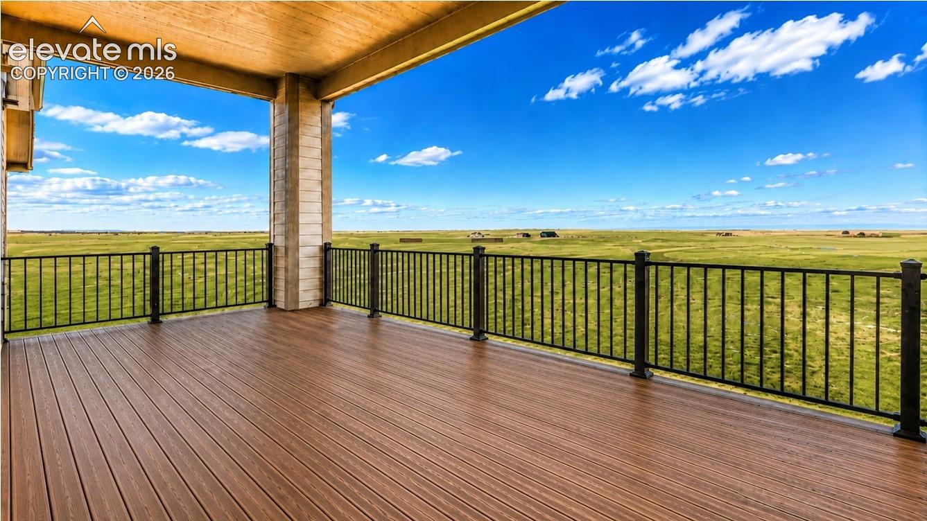 Expansive covered deck featuring wood-finish composite decking and black metal railings