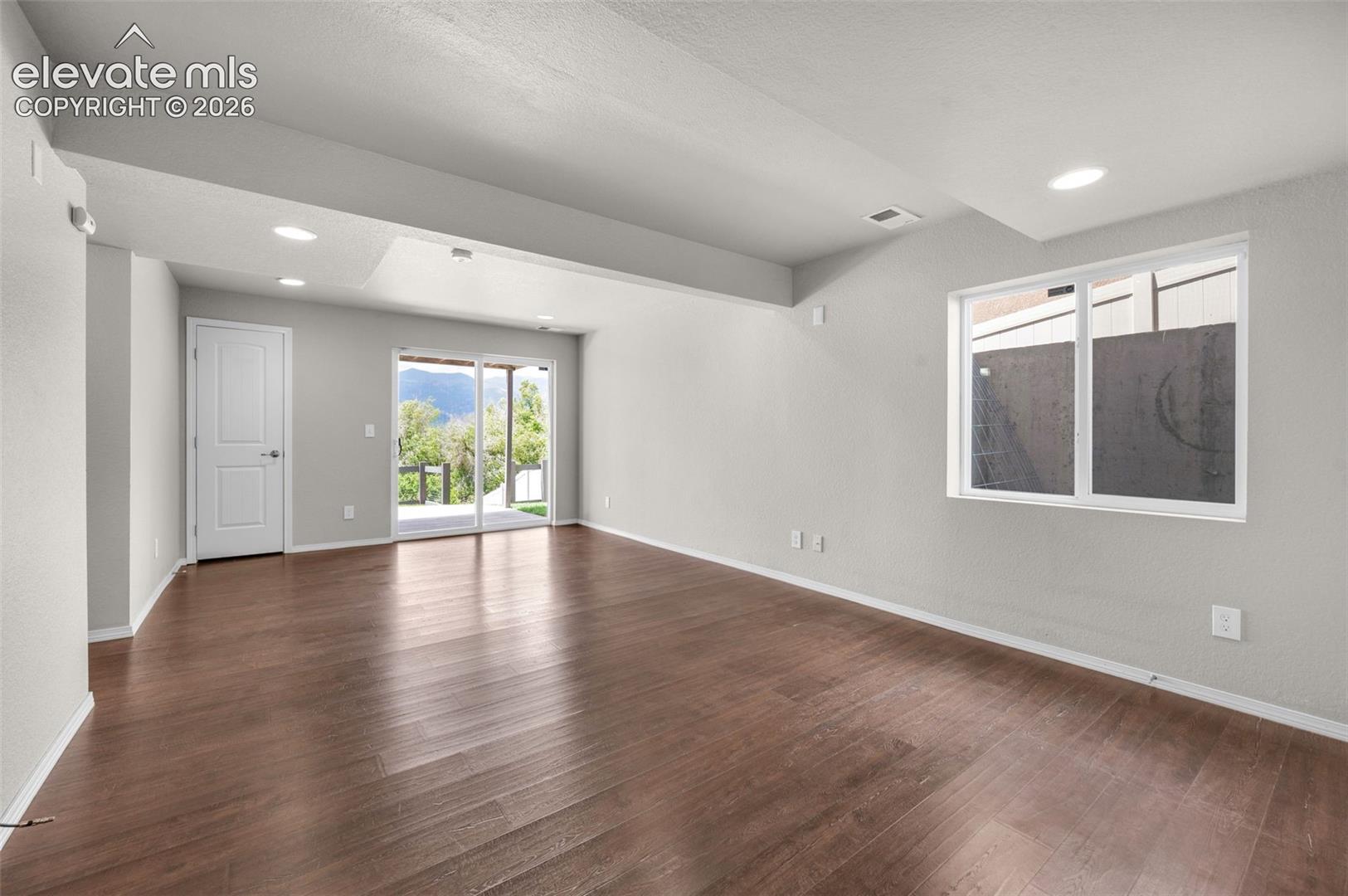 Spacious Rec Room interior featuring wood-finish flooring, recessed lighting, and light gray walls