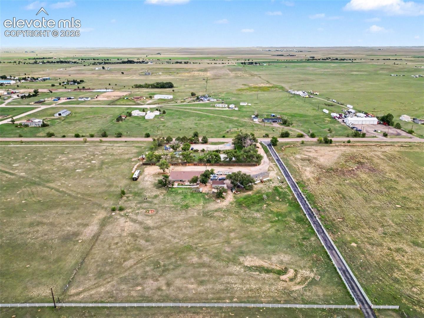 Rear view showcasing the impressive size of the property, expansive open space, mature surroundings, and plenty of room to enjoy the privacy and possibilities this acreage offers.