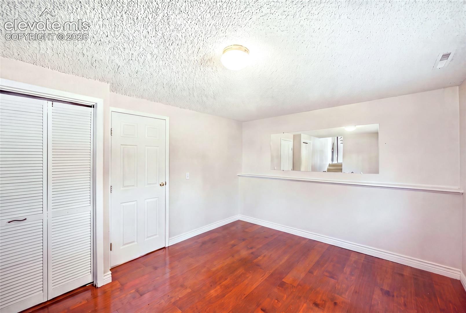 Lower level bedroom with wood flooring.  AI removed items from bedroom