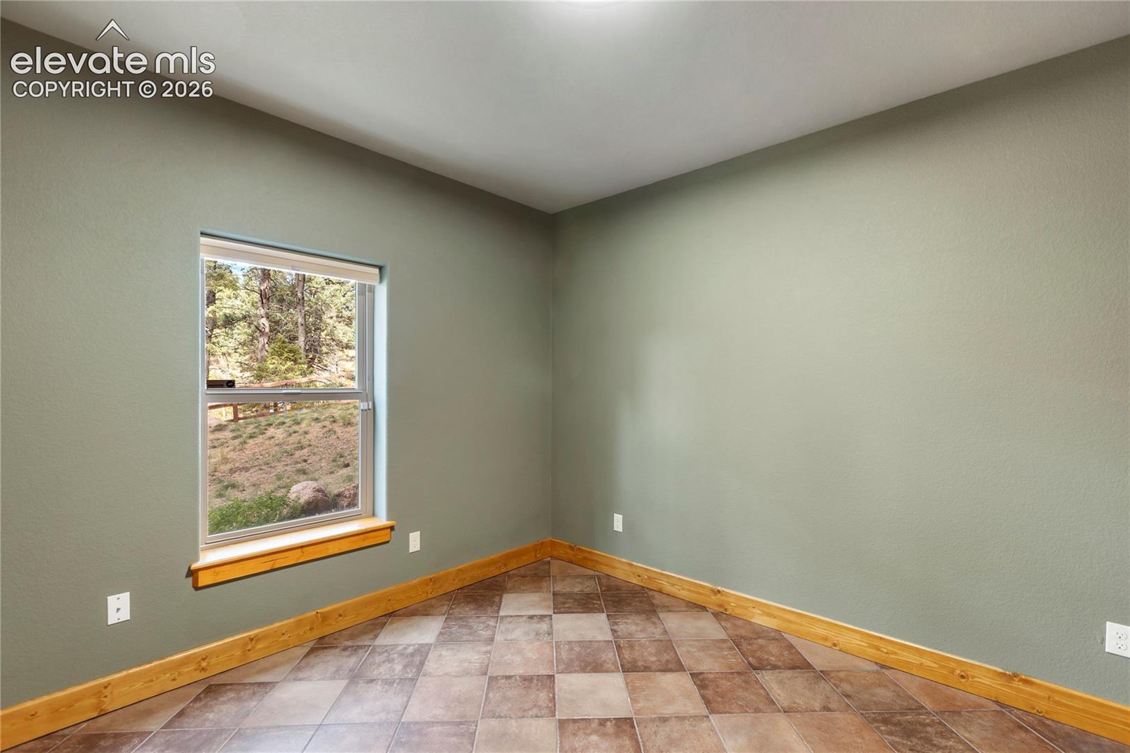 Neutral-toned walls paired with checkered tile flooring, natural wood-finish window sill, and wood-finish trim accents