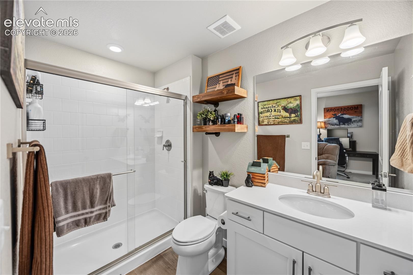 GUEST SUITE LUXURY — This private en-suite bath features a walk-in shower, creating a comfortable and refined retreat for overnight guests.
