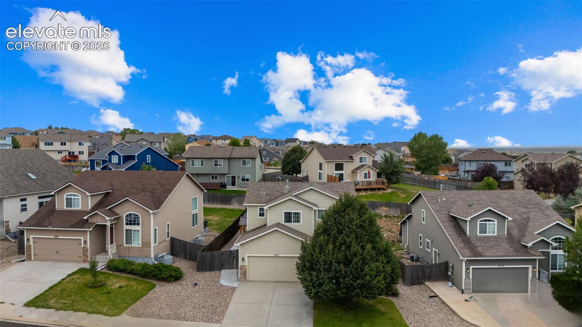 Residential neighborhood featuring multiple detached homes with various exterior finishes, attached garages, and pitched roofs